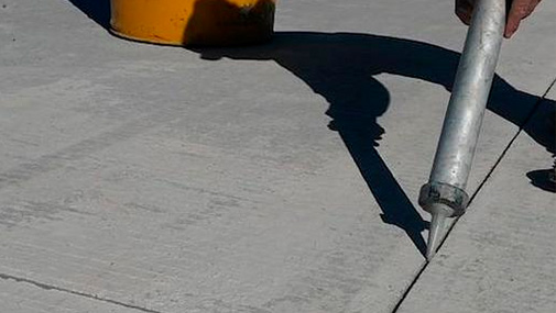 A construction worker is guiding a cement mixer truck chute as concrete is being offloaded for a new house footing. The background is overcast blue sky with another worker, wearing a safety vest, cleaning a mixer chute. http://www.banksphotos.com/LightboxBanners/Concrete.jpg